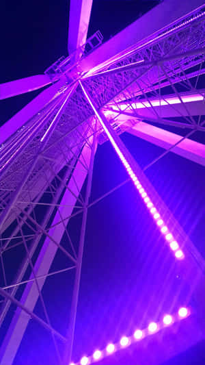 一個發光的紫色摩天輪高聳在夜空中。 — 淺紫色動態圖片 壁紙