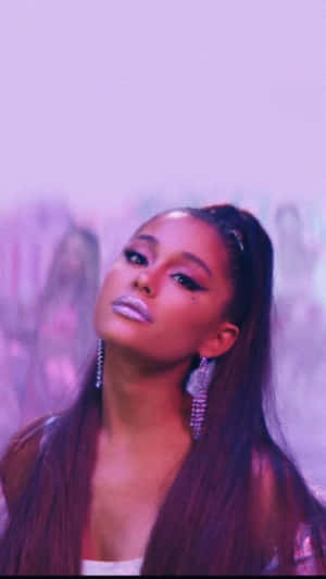 Ariana Grande 在迷人的紫色燈光下，閃爍的耳環和化妝。