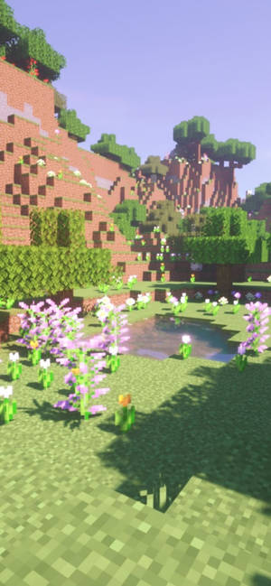 像素化Minecraft場景，有花、池塘同樹木，喺日光之下。 — 紫色 iPhone 壁紙