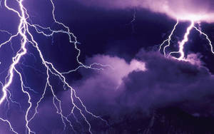 夜間山峰上方被明亮閃電照亮的紫色暴風雨雲。