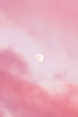 暮色中帶有發光月亮和柔軟雲朵的粉紅天空。