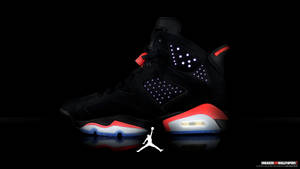 黑色Jordan 6運動鞋，帶有發光點綴和白色Jumpman標誌，置於反光表面。