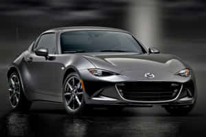 銀色Mazda MX-5 Miata跑車在潮濕路面上，工作室燈光下。
