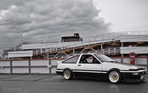 白色和黑色的AE86跑車停放在多層停車場。