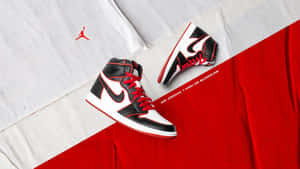 Air Jordan 1 high OG Bloodline 運動鞋放在紅色和白色布料上，帶有標誌。