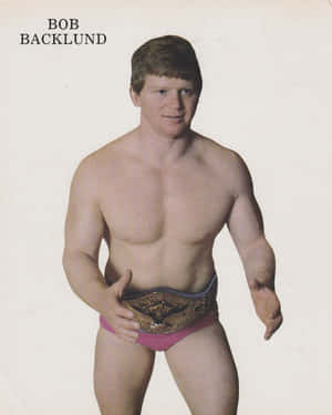摔角手 Bob Backlund 穿著粉紅色短褲，手持冠軍腰帶。