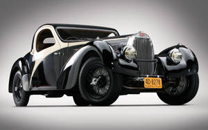 復古黑色和奶油色布加迪雙門轎車，配備鋼絲輪轂和鍍鉻格柵。