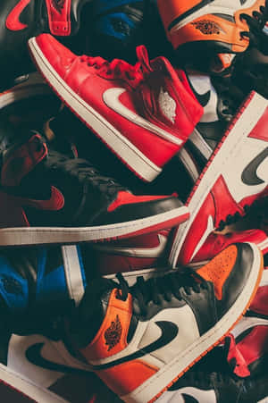 堆疊的紅色、黑色和橙色 Air Jordan 運動鞋收藏。 — Air Jordan GIF 壁紙