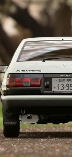 白色豐田AE86 Trueno跑車停泊在碎石路上。