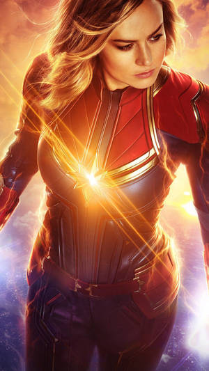 Captain Marvel 身穿戰衣，胸前有發光的星爆，背景是宇宙。