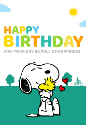 史努比和胡士托在陽光明媚的場景中擁抱，帶有「Happy Birthday」文字和心形。 — 生日蛋糕 壁紙