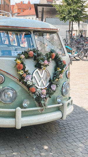 城市街道上裝飾著花卉心形花環的復古VW廂型車。