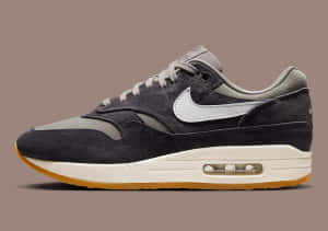 深灰色 Nike Air Max 1 運動鞋，帶有白色勾勾和橡膠鞋底。
