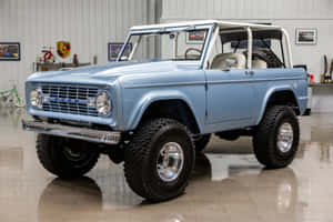 車庫中淺藍色經典福特Bronco，帶有鍍鉻細節和大輪胎。