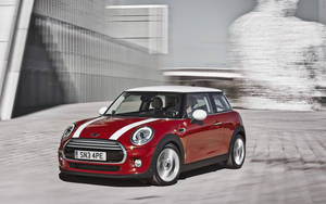 紅色MINI Cooper白色車頂在現代都市環境中飛馳。