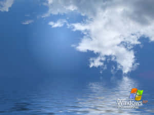 藍天白雲倒映在平靜的海面上，帶有 Windows XP 標誌。