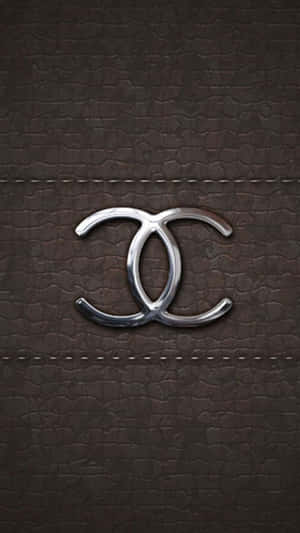 銀色 Chanel 標誌在棕色皮革上，帶有縫線