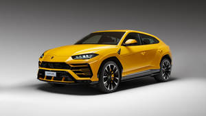 影樓環境中的黃色林寶堅尼 Urus SUV，背景簡潔。