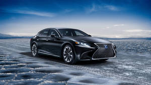 黑色Lexus房車在夜間冰凍湖上，星空和山脈