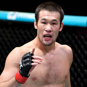格鬥籠中的武術選手，戴著黑色手套和紅色腕帶。