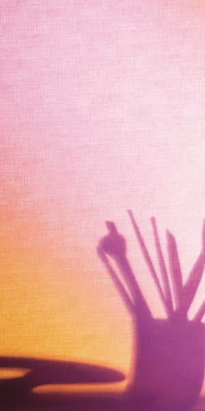 在紋理粉紅和橙色背景上的畫筆和調色板陰影。 — 美景 壁紙