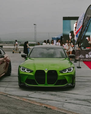 戶外車展中一輛亮綠色BMW M3，附近有參加者。