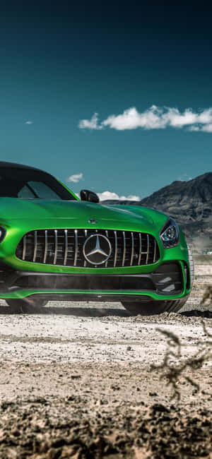 日落時分，綠色 Mercedes-AMG GT 跑車停在山附近的泥路上。 — Galaxy M36 壁紙