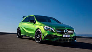 日落時分海岸公路上的綠色 Mercedes-AMG A45 S 跑車。