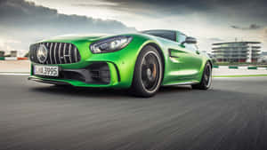 綠色Mercedes-AMG GT S在賽道上疾馳，帶有動態模糊效果。 — 汽車 壁紙