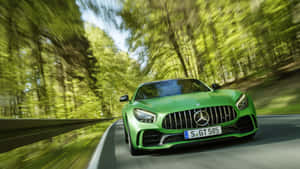 綠色Mercedes-AMG GT S在日落時分穿過森林。 — 汽車 壁紙