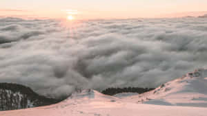 日出時雲海上的雪山峰
