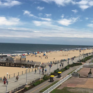 夏日陽光普照，沙灘同木板路人頭湧湧，人們享受海洋同步行徑。 — 海洋 壁紙