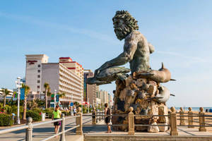 酒店附近海灘木板路上的青銅海神與海豚雕像。 — 海灘 壁紙