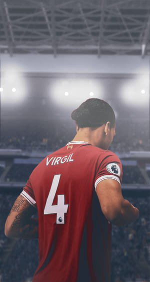 足球員 Virgil van Dijk 身穿紅色利物浦球衣，夜晚在球場上。