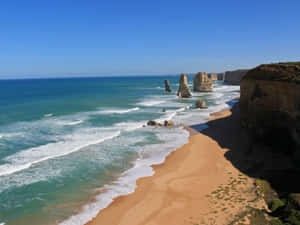 陽光明媚的海灘上，海岸懸崖和岩石形態與碧綠的海浪。