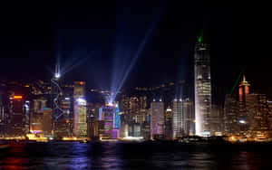 香港夜景，激光束和發光的摩天大樓倒映在水面上。 — 夜景城市 壁紙