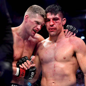 兩名滿臉是血的疲憊MMA拳手在比賽後互相擁抱。
