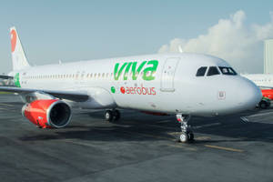 Viva Aerobus飛機在晴朗天空下停在機場停機坪上。 — 灰色 GIF 壁紙
