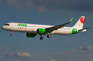 Viva Aerobus 飛機在飛行中，起落架放下，背景為多雲的天空。