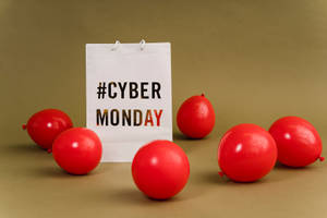 白色購物袋，帶有 #CYBER MONDAY 文字，周圍環繞著紅色氣球，背景為棕色。 — 紅色 壁紙
