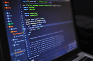 手提電腦屏幕顯示 Ruby on Rails 程式碼，鍵盤模糊。