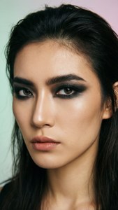 在工作室肖像中，帶有戲劇性黑色眼線和柔和粉紅色嘴唇的女士。