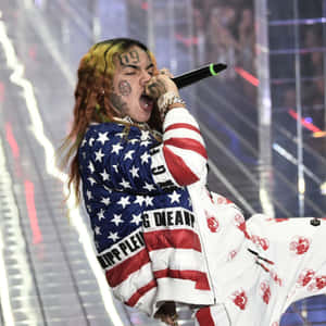 Lil Pump 穿著美國國旗外套，帶有骷髏圖案，在舞台上說唱。