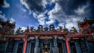 在暴風雨天空下，飾有龍雕塑的宏偉寺廟。