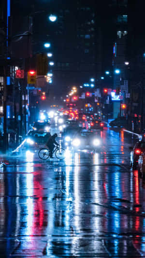一個騎單車者在夜間穿過下雨的城市街道，帶有發光的反射。
