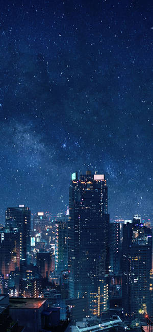 夜晚城市景觀，星空下銀河系照亮建築物。
