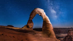 在繁星點點的夜空下發光的石拱，銀河清晰可見。