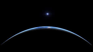 彎曲的地球地平線在黑色太空中發出藍光，上方有一顆明亮的星星。