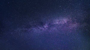 銀河系在漆黑的夜空中閃爍著紫色和藍色的星星。 — 月色夜空 壁紙