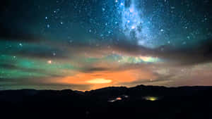 星空下，極光映照著黑暗的山巒剪影。